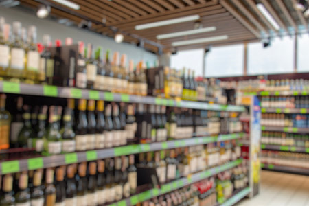 A blurred view of a supermarket aisle with bottles of alcoholic beverages. The atmosphere of a retail department selling beverages for grocery shopping and the sale of alcoholic beveragesの写真素材