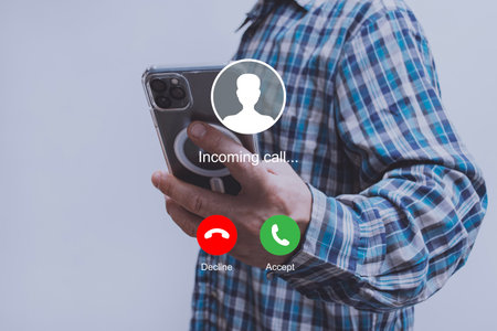 Close-up image of a man holding a smartphone, about to answer or decline an incoming call. Concept...