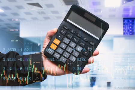 Professional holding digital calculator with financial trading charts and stock market data overlay....