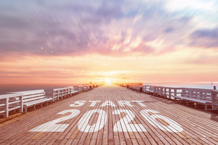 Motivational new year start concept with text Start 2020 on wooden pier leading to sunrise over the sea. Concept new beginnings, goals and inspiration for success.の写真素材