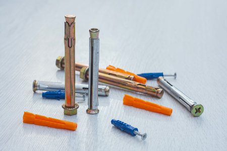 Variety of metal expansion anchors, sleeve anchors, nylon wall plugs, and screw-in anchors scattered...