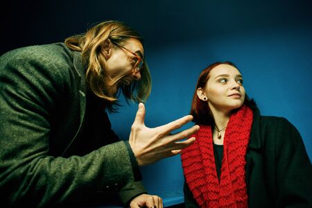 A couple having a fight. The young woman is terrified by her partner yelling at her.の写真素材