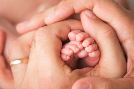 Loving parent hold babys legs. Happy childhood. Parental care. Concept of a happy family.の写真素材