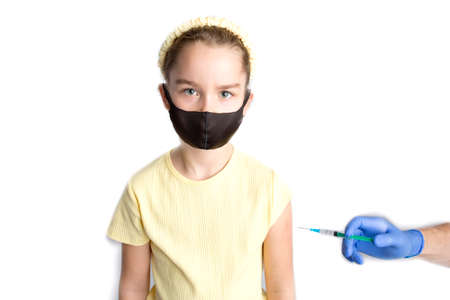 A nurse is giving vaccinations to patients with a syringe. A doctor vaccinates a teenage girl in a hospital.の写真素材