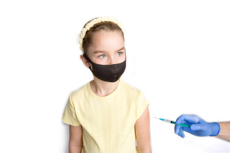 A nurse is giving vaccinations to patients with a syringe. A doctor vaccinates a teenage girl in a hospital.の写真素材
