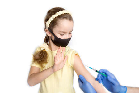 A nurse is giving vaccinations to patients with a syringe. A doctor vaccinates a teenage girl in a hospital.の写真素材