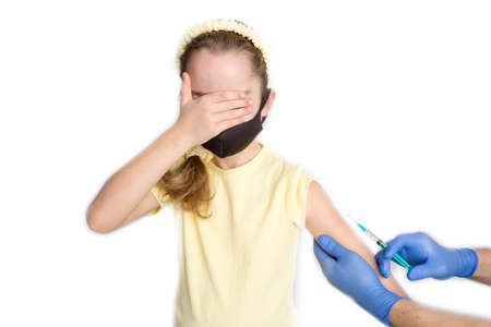 A nurse is giving vaccinations to patients with a syringe. A doctor vaccinates a teenage girl in a hospital.の写真素材