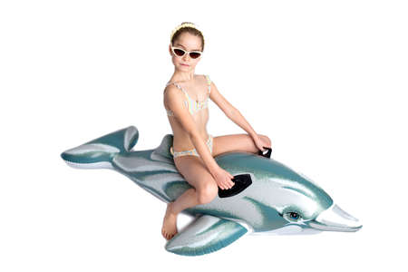 Happy child in a in a bathing suit on an inflatable dolphin.  pandemic and healthy lifestyle concept.の写真素材