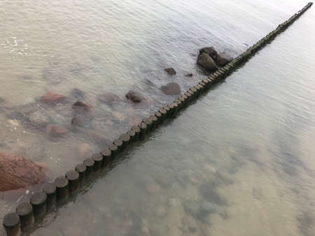 Breaking waves on a wooden breakwater on the Baltic Sea coast.の写真素材