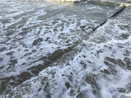 Breaking waves on a wooden breakwater on the Baltic Sea coast.の写真素材