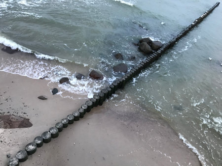 Breaking waves on a wooden breakwater on the Baltic Sea coast.の写真素材