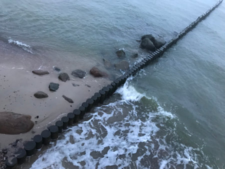 Breaking waves on a wooden breakwater on the Baltic Sea coast.の写真素材
