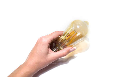 Electric diode light bulb in hand, isolated on white studio background.の写真素材