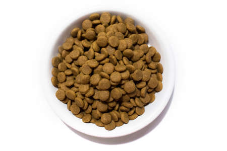 Dry food for cats and dogs in a white bowl. Studio white background.の写真素材