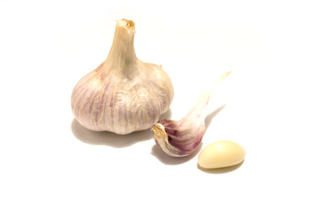 One head of garlic and two cloves of garlic. Isolated on white background.の写真素材
