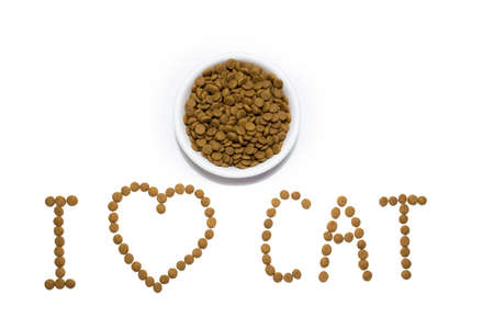 Dry food for cats and dogs in a white bowl. Heart from the food. Inscription I love cats. Studio white background.の写真素材