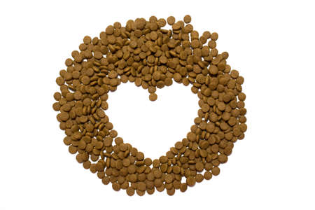 Dry food for cats and dogs on a white background. Heart from the food.の写真素材
