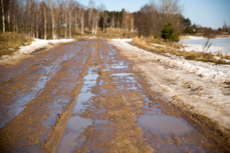 Rural dirty damaged road with muds and holesの写真素材