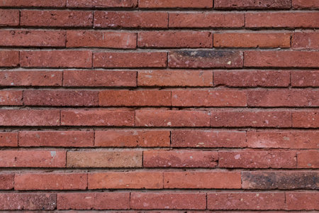 Texture of a wall made of old raw bricks. The walls are deep red.の写真素材