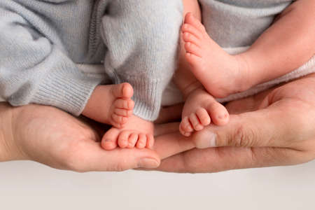 Twins are babies. A close-up photo of the legs of newborn twins. Feet and fingers of a...