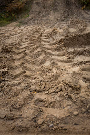 Wheel trail on sandy ground from large transport, tractor on construction site, sandy road