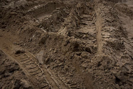 Wheel trail on sandy ground from large transport, tractor on construction site, sandy roadの写真素材