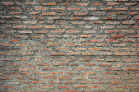 Red background of old vintage brick wall texture. Close up view of old stone brick wall with...