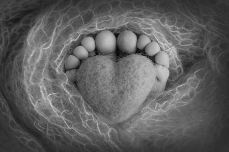 The tiny foot of a newborn baby. Soft feet of a new born in a wool blanket. Close up of toes, heels...