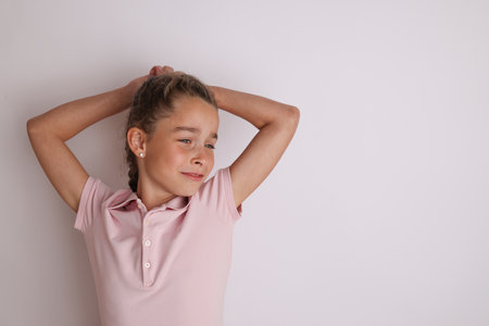 Little emotional teen girl in pink shirt 11, 12 years old on an isolated white background. Childrens studio portrait. Place text, to copy space for inscription, advertising childrens goods.の写真素材