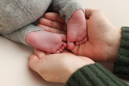 Feet of the newborn on the palms of the parents. childs toes, heels and feet on a white background.の写真素材