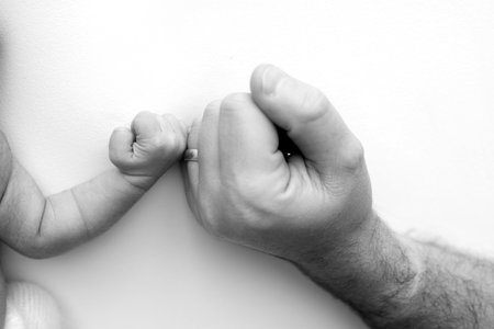 The newborn baby has a firm grip Close-up little hand of child and palm of mother and father.の写真素材