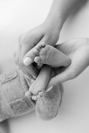 The palms of the father, the mother are holding the foot of the newborn baby on white background.の写真素材