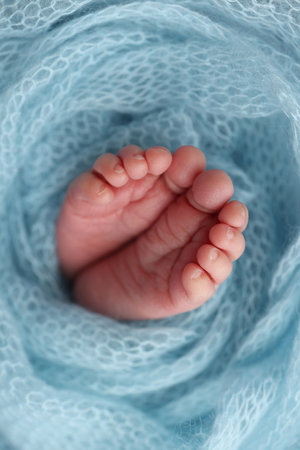 Baby foot on blue soft coverlet, blanket. Close-up of tiny, cute, bare toes, heels and feet of a newborn girl, boy.の写真素材