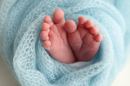 Baby foot on blue soft coverlet, blanket. Close-up of tiny, cute, bare toes, heels and feet of a newborn girl, boy.の写真素材