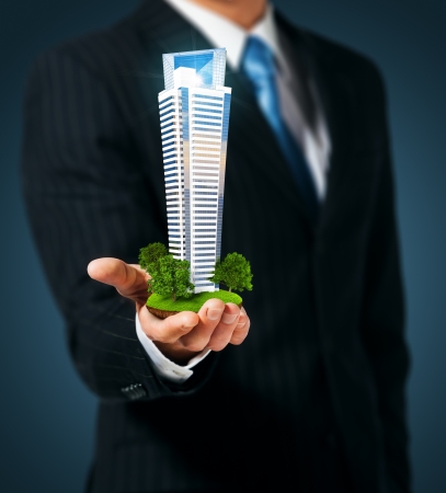 Man holding a skyscraper in hand Man holding a skyscraper in hand