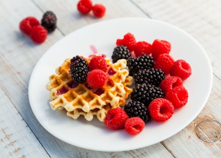 Blackberry and raspberry with a waffle on a white plateの写真素材