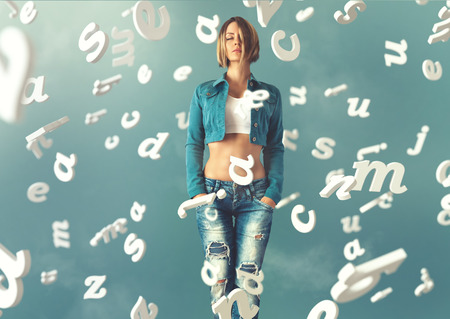 Sexy young woman in a trendy clothes with letters flying arround her
