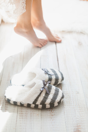 Soft photo of woman on the bed with sunlight from window in bright white roomの写真素材