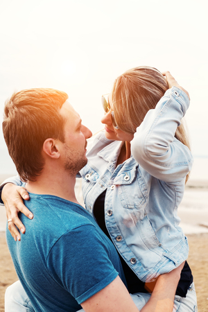 Young happy couple in love kissing on the beach against summer sunset. Happy young family. Travel and vacation concept.の写真素材