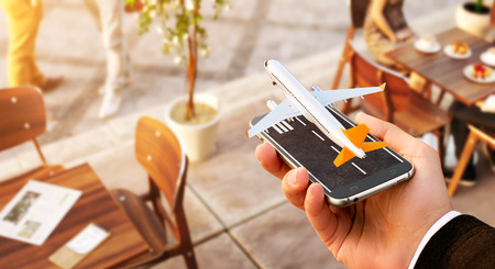 Smartphone application for online searching, buying and booking flights on the internet. Online check-in. Unusual 3D illustration of commercial airplane taking off on smartphone in handの写真素材