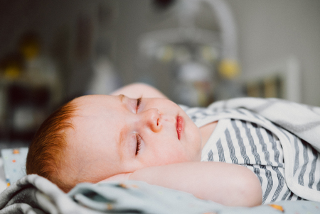 Cute little baby sleeping in a bed. Happy Family concept.の写真素材