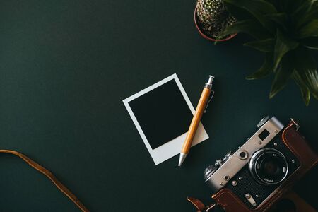 Top view of a flat lay film camera in a case an empty  shot and a pen lie on a dark table. The concept of memories and unforgettable moments. Advertising spaceの写真素材