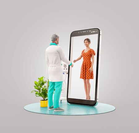 3d illustration of a male doctor standing in front of smartphone screen shaking hands with his patient. Health care Smartphone apps. Online medical consultation and support concept.の写真素材