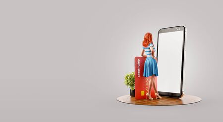 Young woman with credit card standing at big smartphone and using smart phone application for shopping an payment. Payment online concept. Unusual 3d illustrationの写真素材