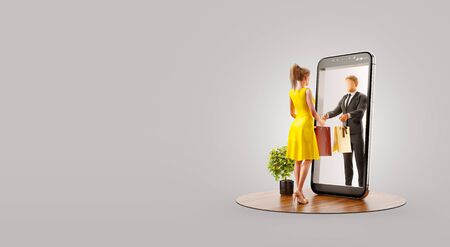 Young man standing at big smartphone and using smart phone application. Smartphone apps concept. Unusual 3d illustrationの写真素材