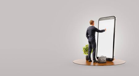 Businessman standing in front of smartphone with Stock market graph. Finance and investment Smartphone apps concept. Unusual 3d illustrationの写真素材