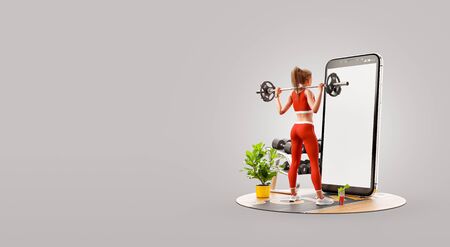 Young woman in gym doing squats with barbell in front of smartphone and using smart phone for exercises. Smartphone sports and gum apps concept. Unusual 3d illustrationの写真素材