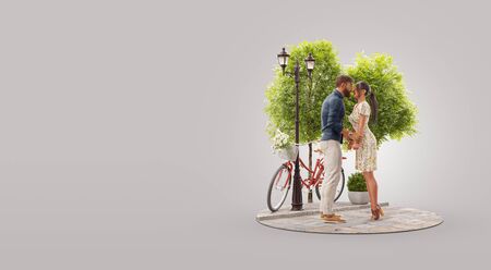 Young beautiful couple in love hugging and looking at each other standing in park. Romantic relationship and family concept. Valentines day. Unusual 3d illustrationの写真素材
