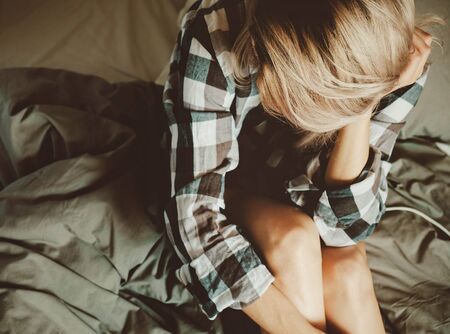 Young beauty female in casual shirt on the bed, top view point.