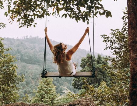 Pretty brunette swinging in a park